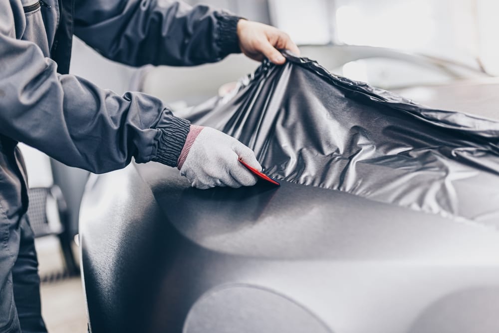 A specialist installing a vinyl wrap on a vehicle